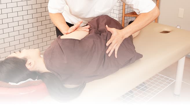 痛みや不調の原因を見極めながら行う施術の様子